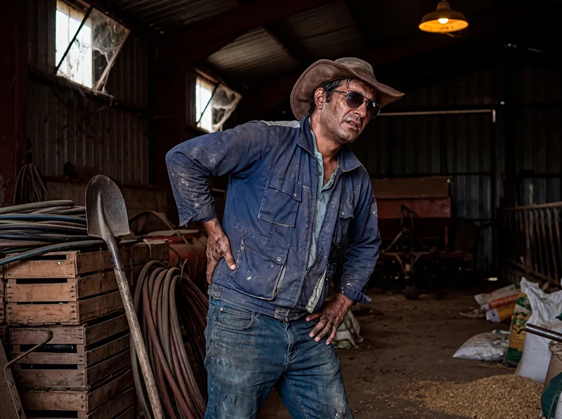 Hombre en granja con dolor de espalda